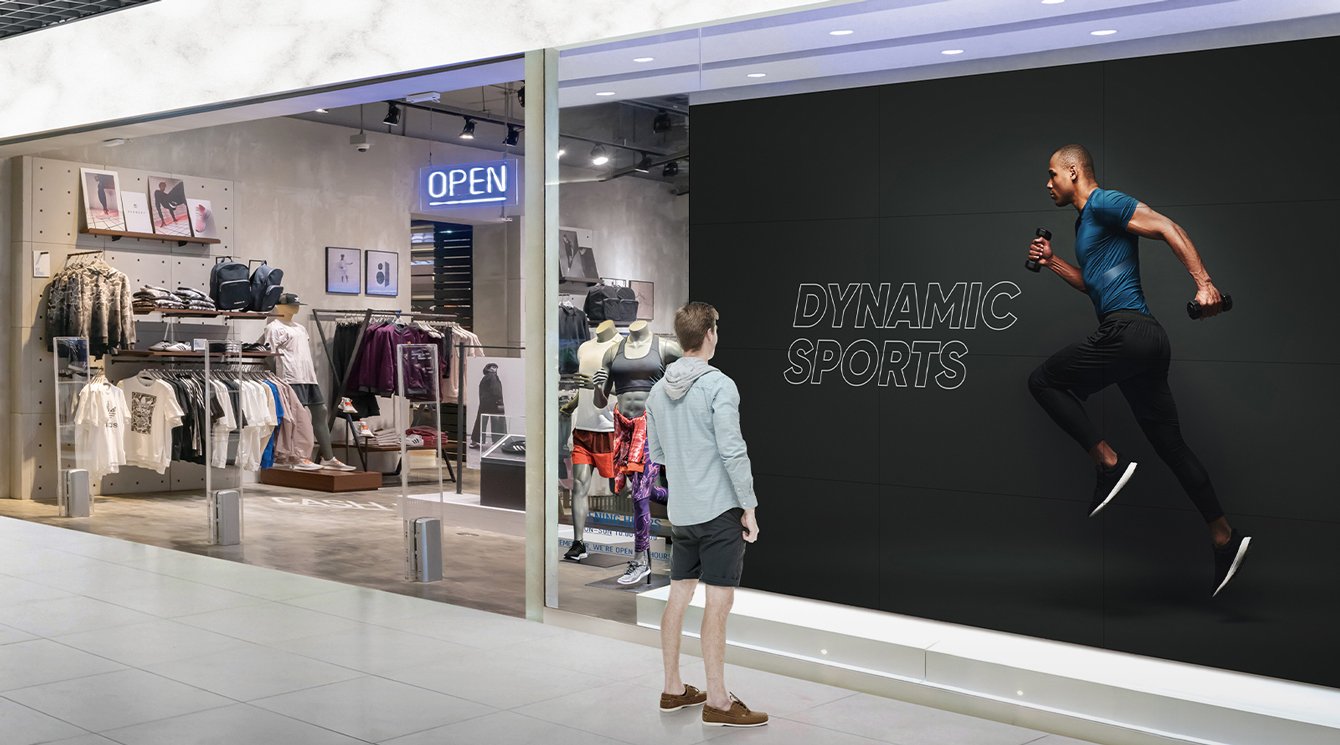 A man admires a 49 inch Slim Bezel Series video wall display at a sports store window