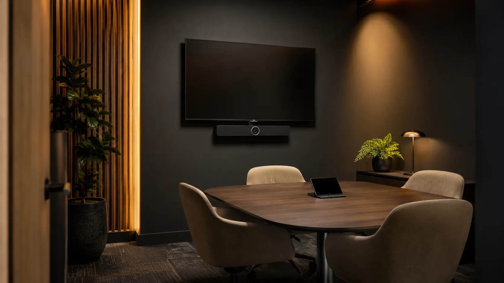 Small Meeting Room & Huddle Space Video Conferencing Australia 1 Small meeting room and huddle space video conferencing setup with all-in-one conferencing bar mounted below display, warm amber lighting, compact 2 to 4 seat collaborative table — Kickstart Computers Australia